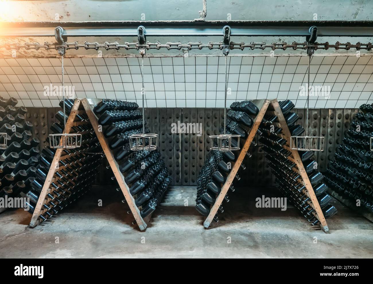 Cantina con stand in legno e bottiglie di vetro. Concetto di vinificazione. Foto Stock