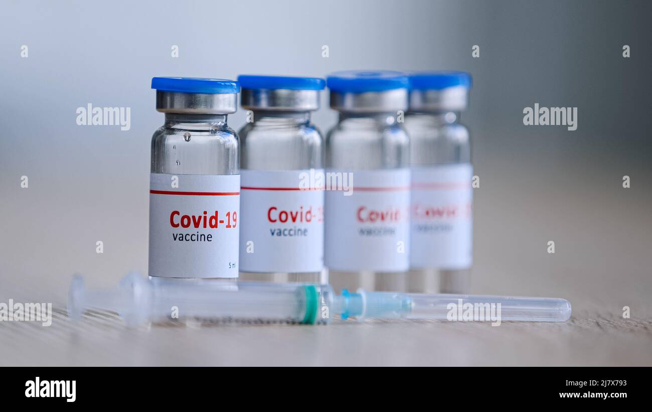 Primo piano quattro bottiglie con covid-19 vaccino rimedio per malattia epidemia medicina cura farmaci stand sul tavolo in ospedale laboratorio clinica farmacia vicino Foto Stock