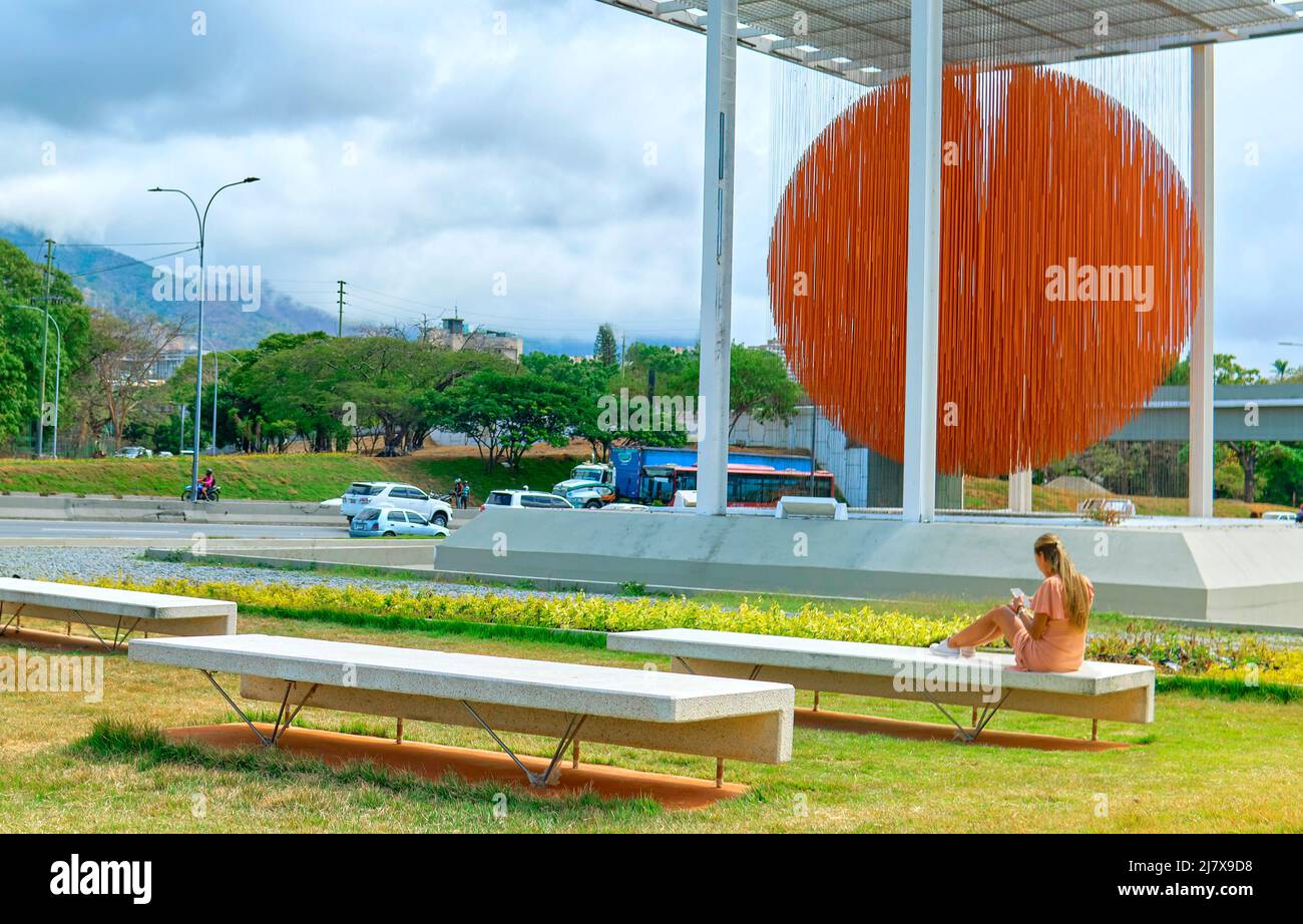 Caracas, Venezuela - 1 maggio 2022. Donna apprezzare l'arte scultura cinetica Esfera Caracas, di Jesus Soto, sulla Francisco Fajardo Highway. Foto Stock