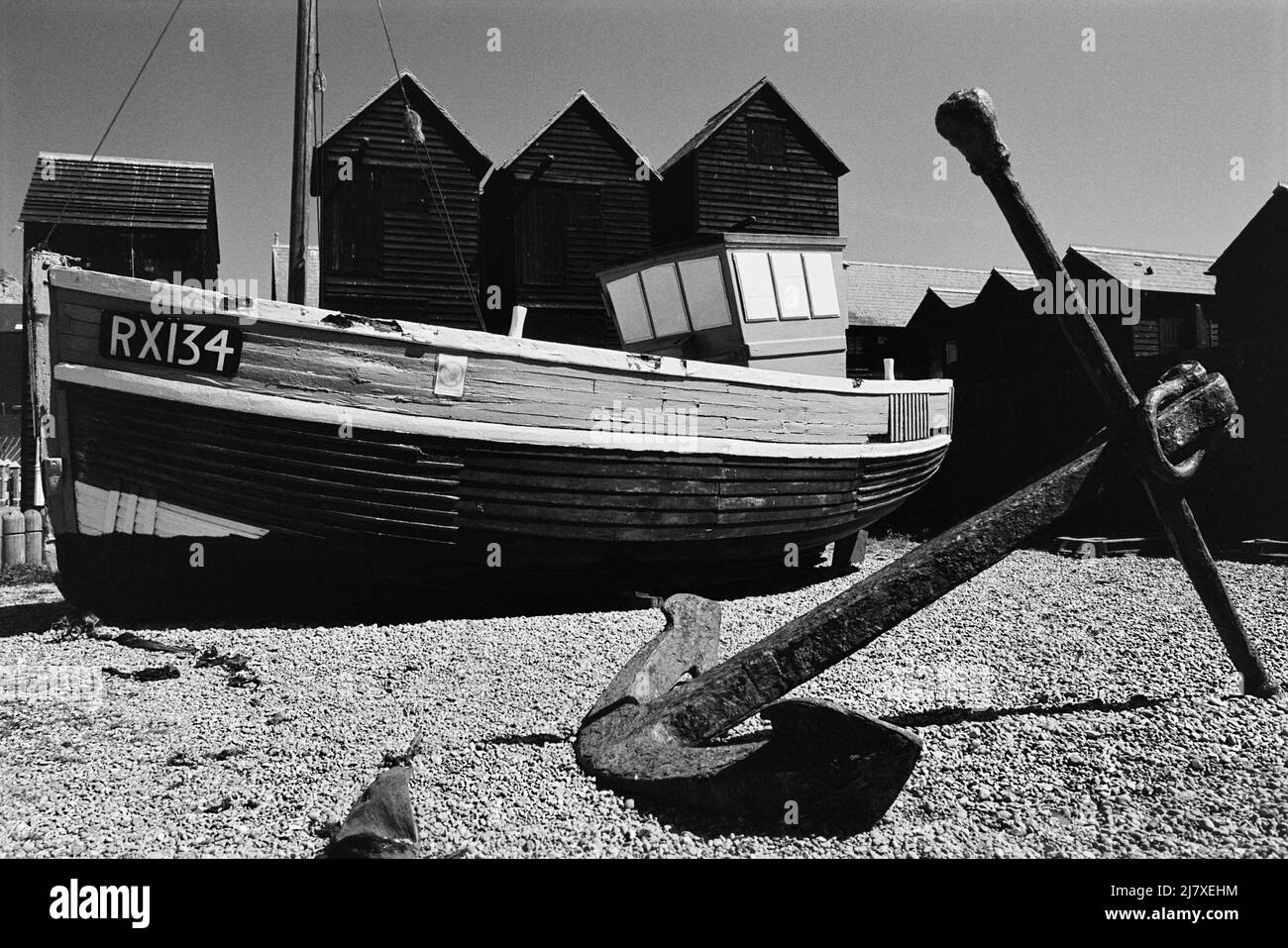 Barche da pesca in camicia e negozi di rete sulla Stade a Hastings, East Sussex, South East England Foto Stock