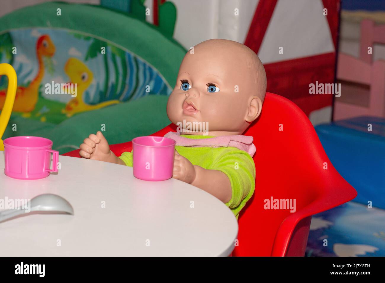 Bambola seduta al tavolo con tè Foto Stock