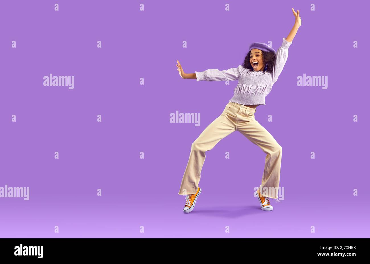 Divertente ragazza teen nero ballare su sfondo viola Foto Stock