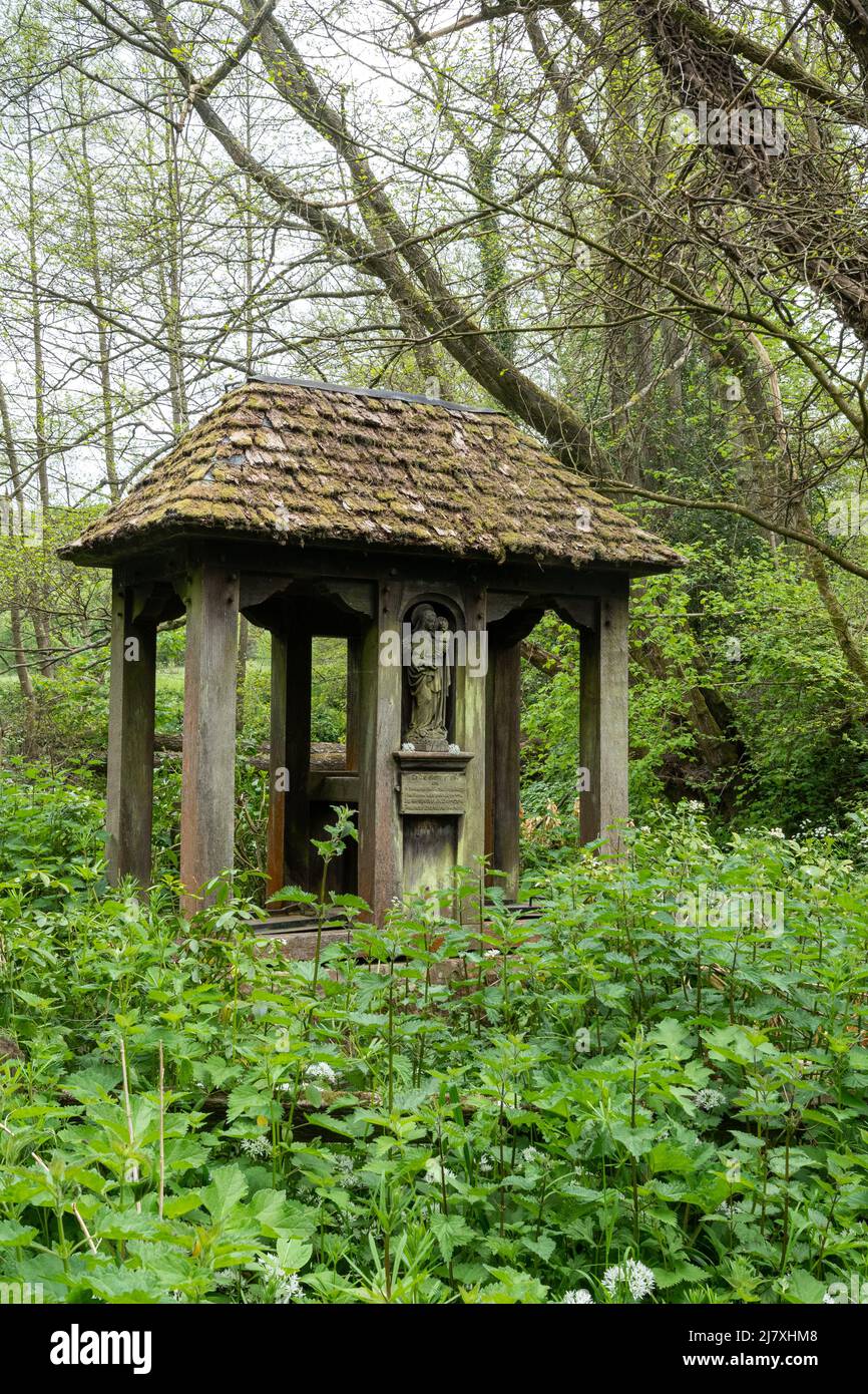 Il pozzo Santo a Dunsfold, un villaggio di Surrey, Inghilterra, Regno Unito, sotto un rifugio o un santuario di quercia vecchia con tetto a groviglio e figura scolpita di Maria e bambino Foto Stock