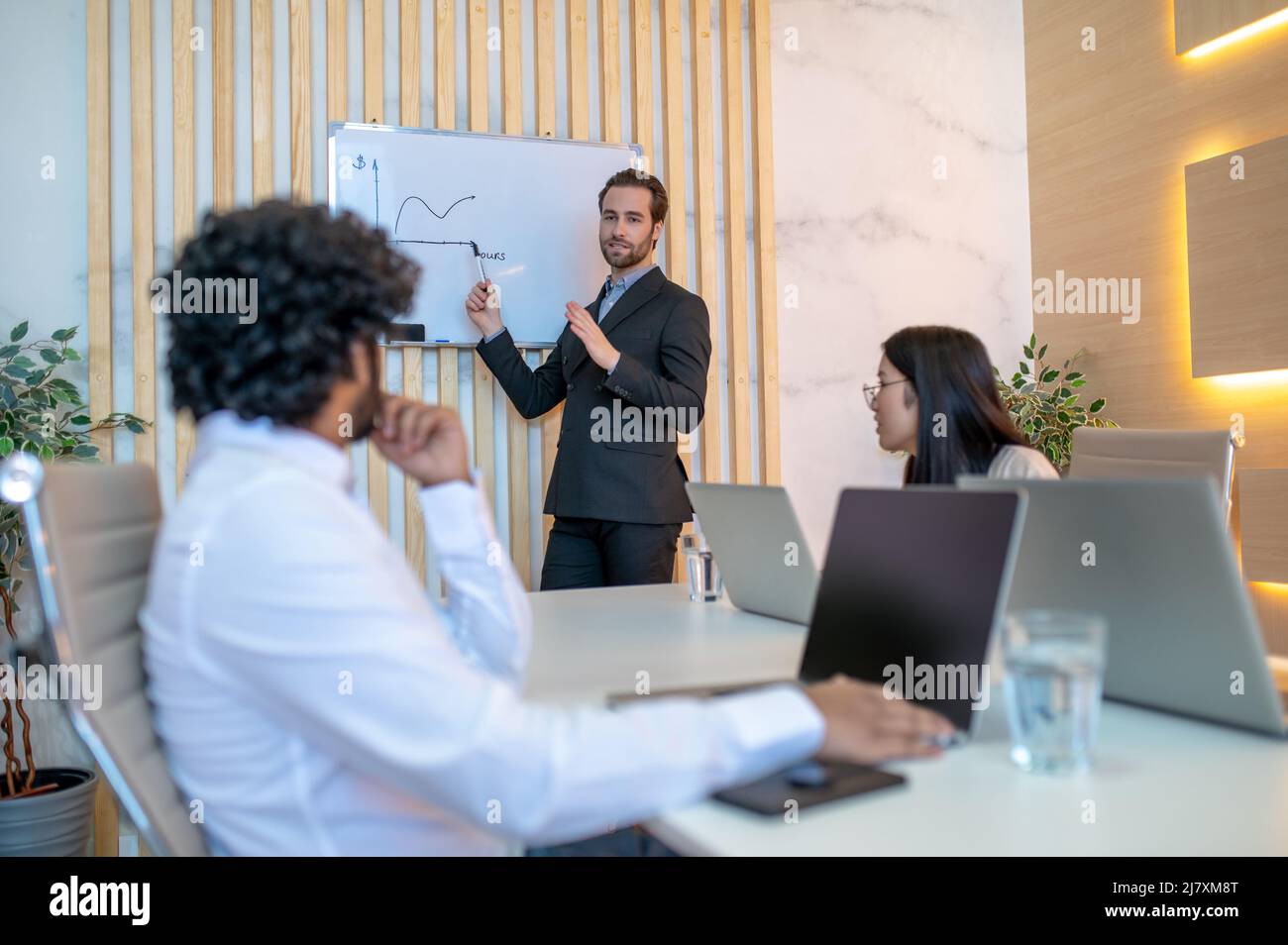 Imprenditore maschile che dà una presentazione grafica dei dati aziendali Foto Stock