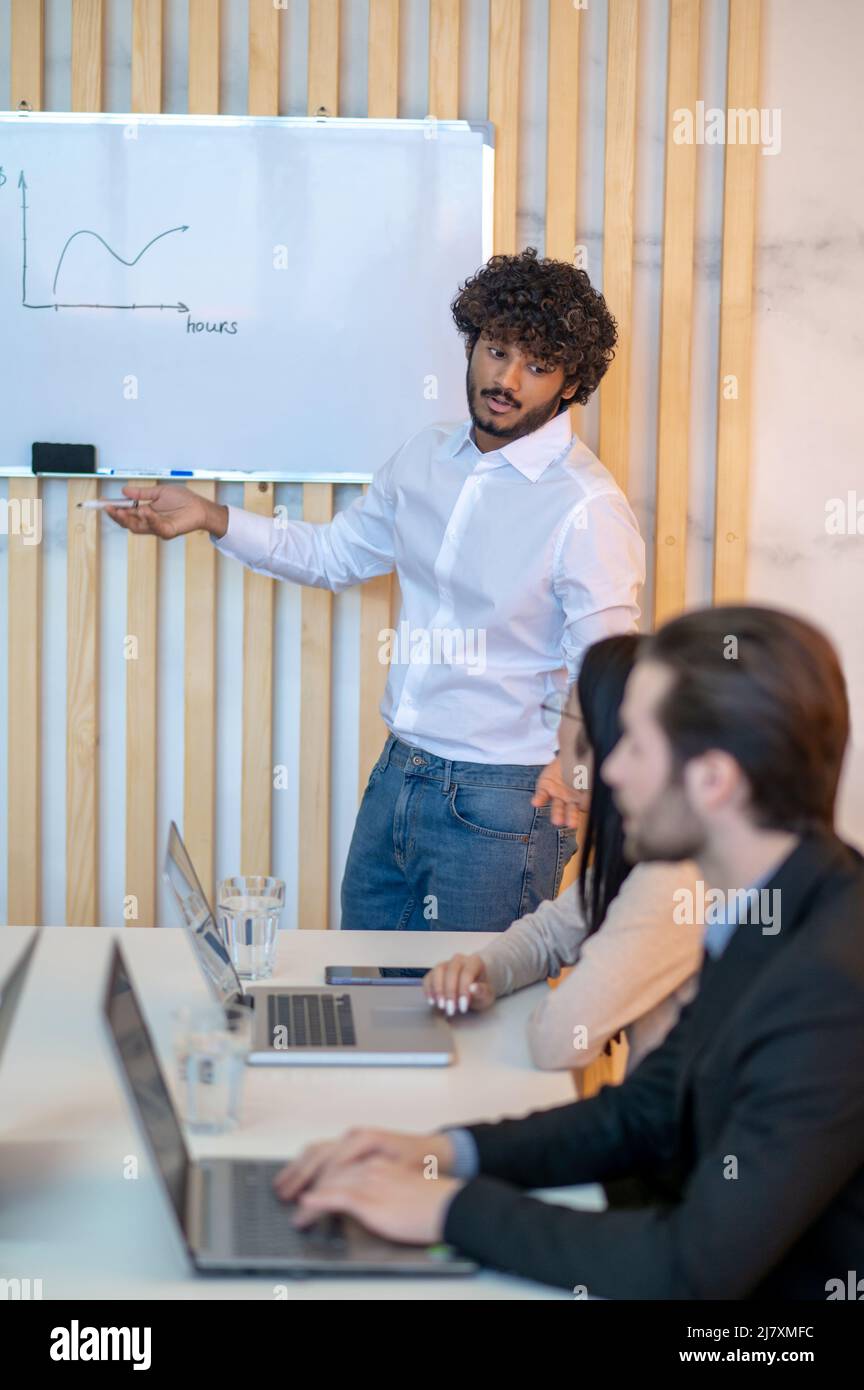 Gesticulando il lavoratore di ufficio che dà una presentazione al suo collega Foto Stock