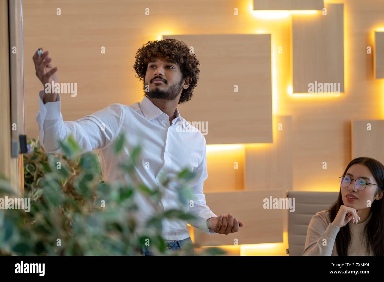 Lavoratore aziendale che presenta la sua collega femminile Foto Stock