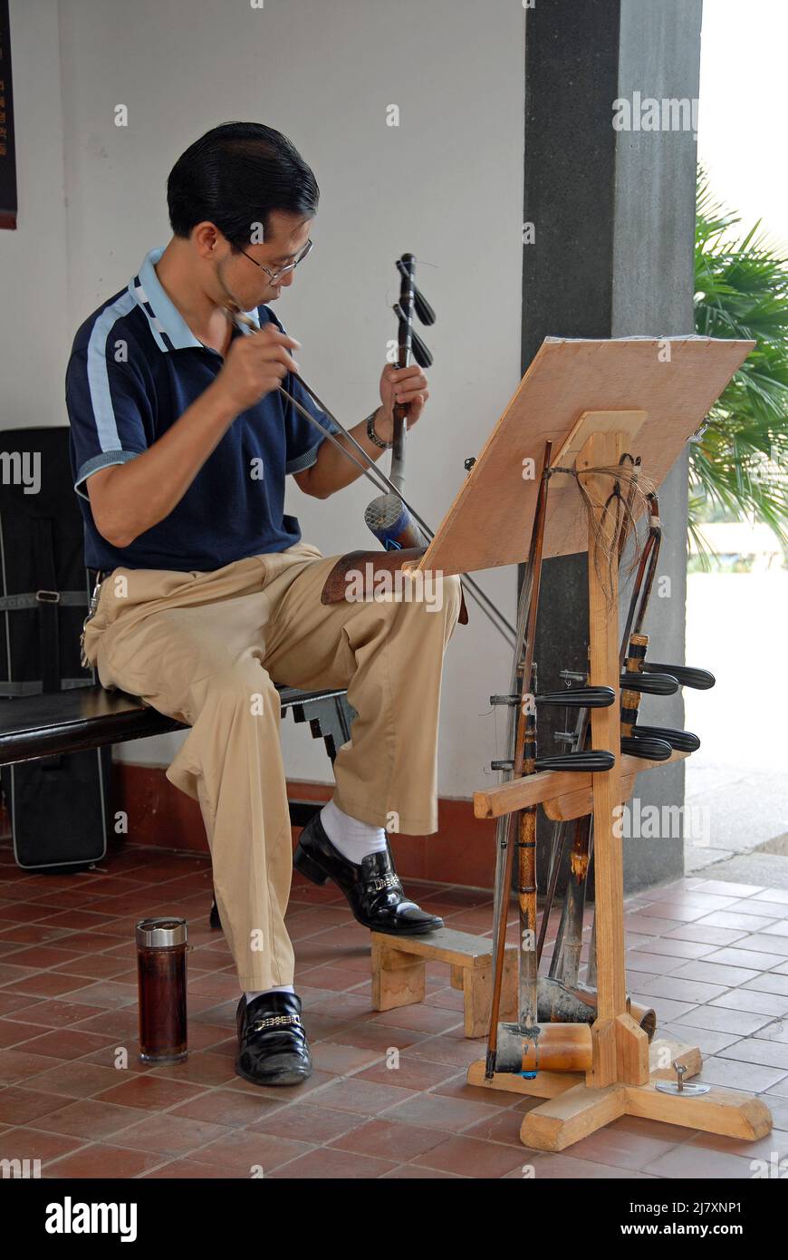 Changsha, Provincia di Hunan, Cina: Uomo che suona un Erhu al Padiglione Tianxin. L'erhu è un tradizionale strumento musicale cinese che assomiglia ad un violino. Foto Stock
