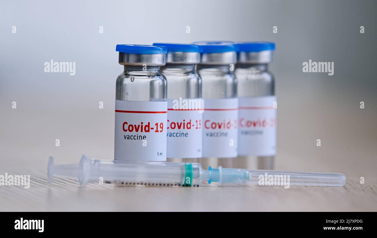 Primo piano quattro bottiglie con covid-19 vaccino rimedio per malattia epidemia medicina cura farmaci stand sul tavolo in ospedale laboratorio clinica farmacia vicino Foto Stock