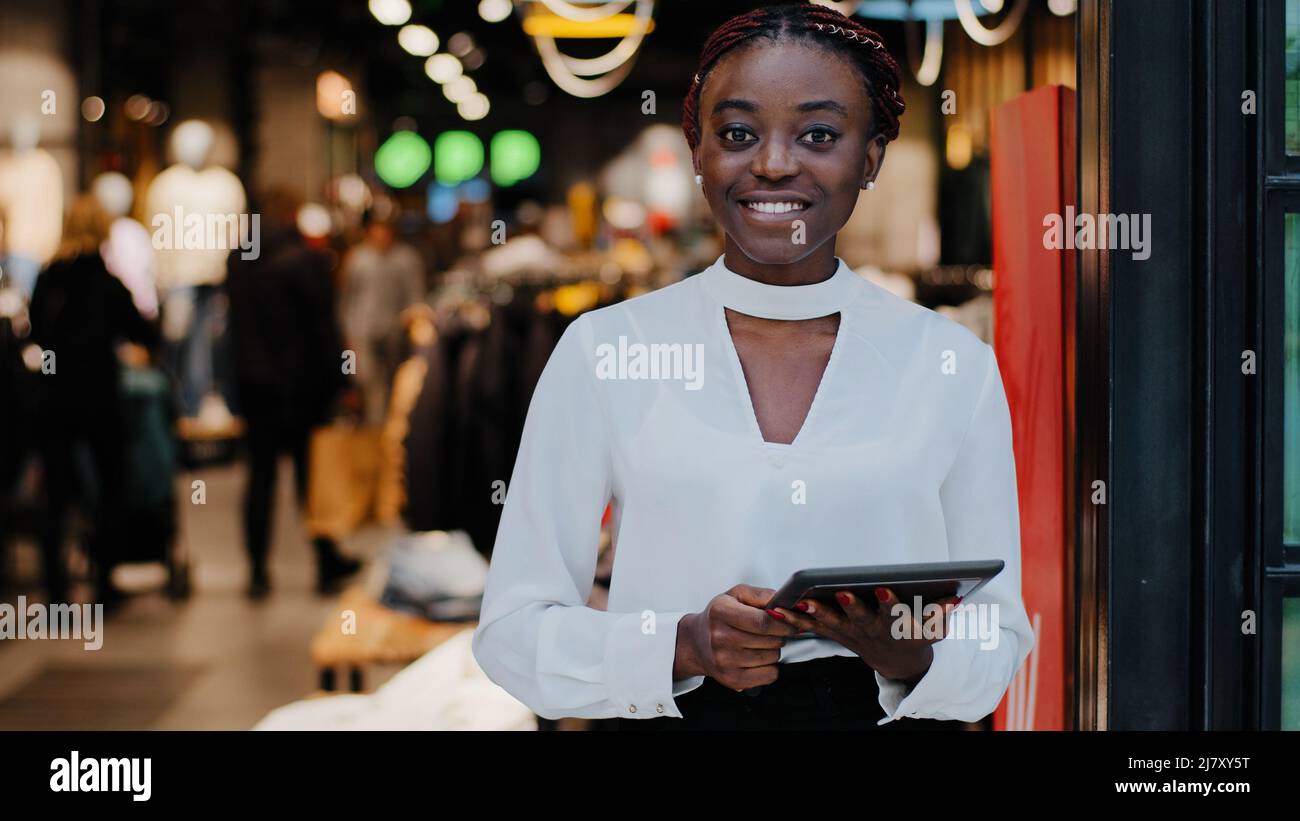 Ritratto afroamericano felice sorridente felice venditore di successo donna consulente in negozio di abbigliamento negoziante boutique dipendente tenendo digitale Foto Stock