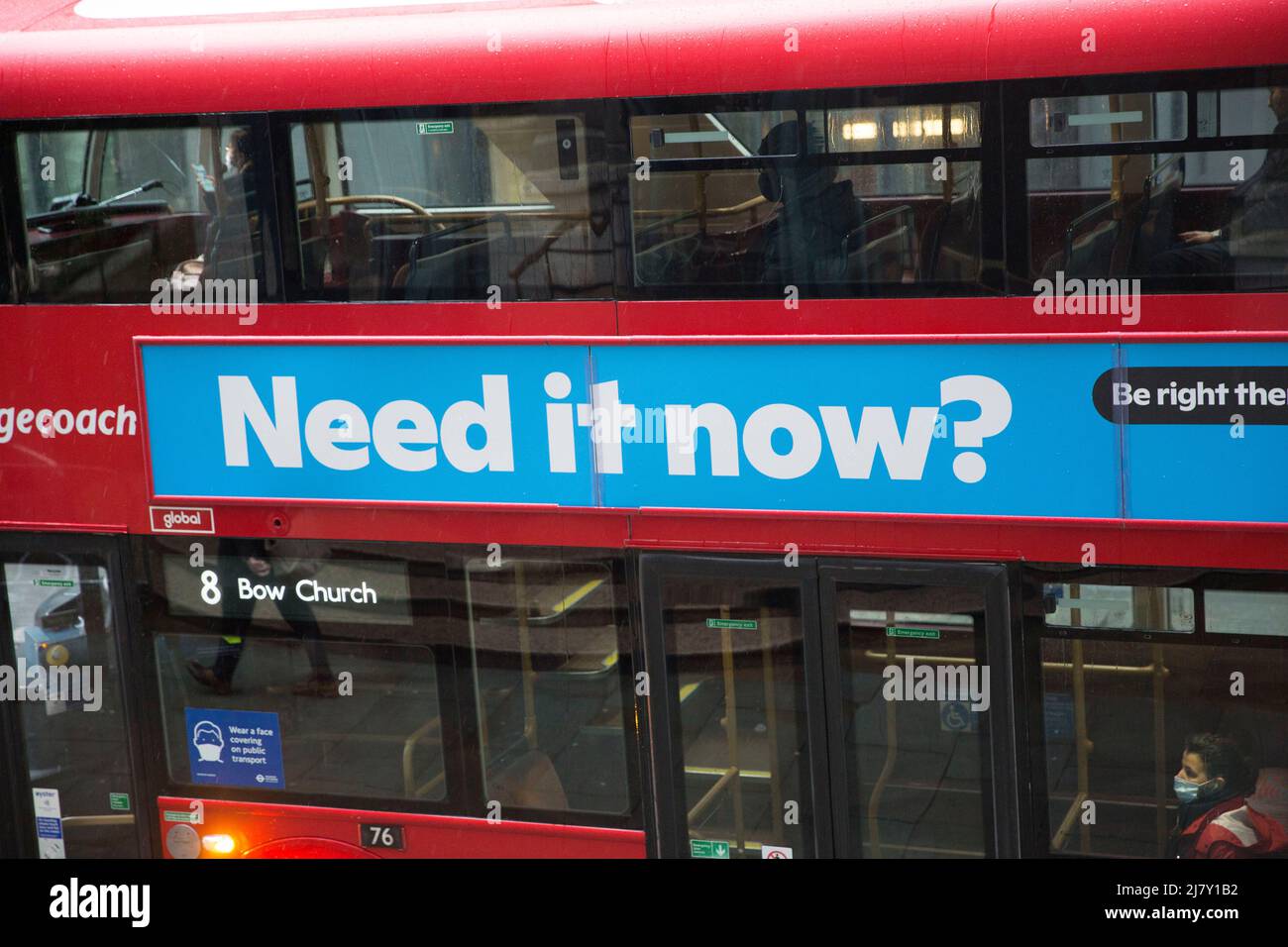 I passeggeri, alcuni che indossano una maschera e altri no, sono visti in un autobus a due piani nella City of London. Foto Stock