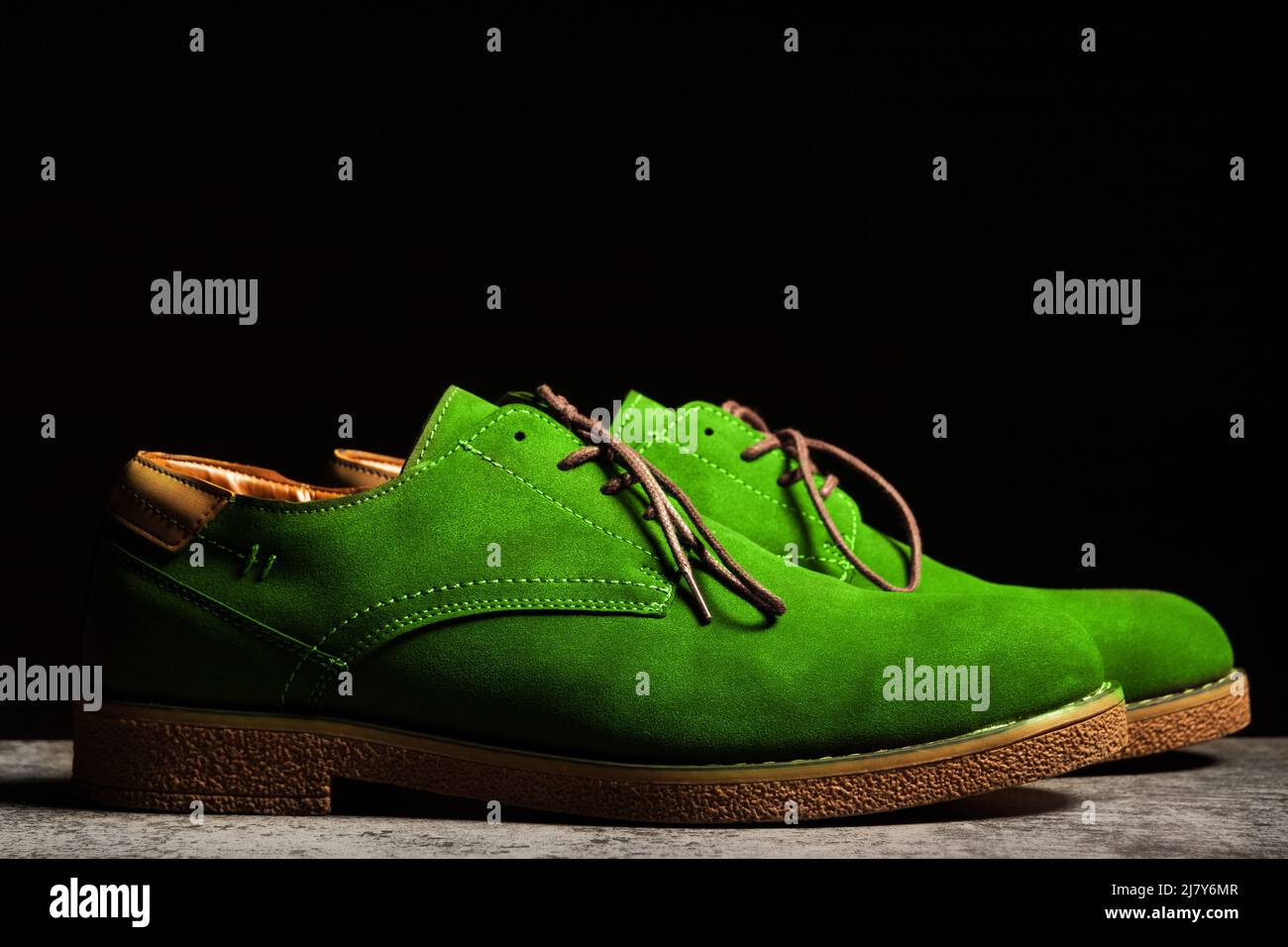 Vista laterale di scarpe da concerto verdi con lacci su sfondo nero Foto Stock