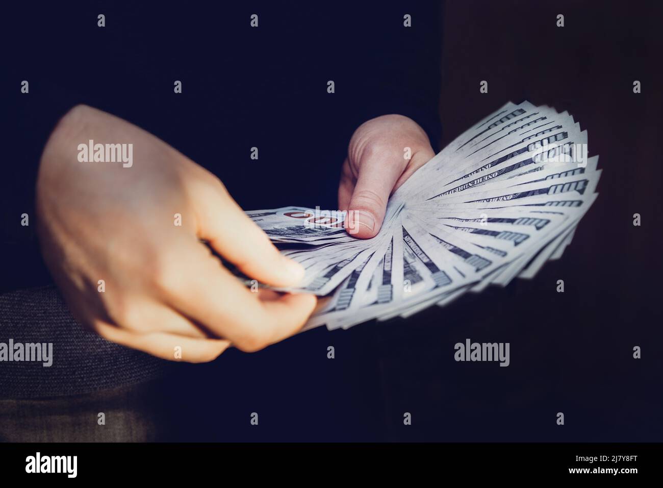 Un uomo tiene un ventilatore di 100 dollari bollette nelle sue mani. Un uomo conta soldi. Foto Stock