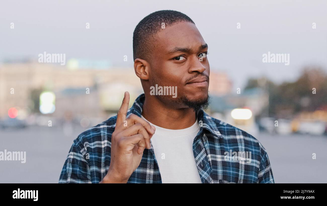 Giovane uomo d'affari americano ragazzo africano in piedi in strada della città all'aperto scuotendo il dito in modo disapprovante gesto di proibizione disaccordo mostra corpo Foto Stock