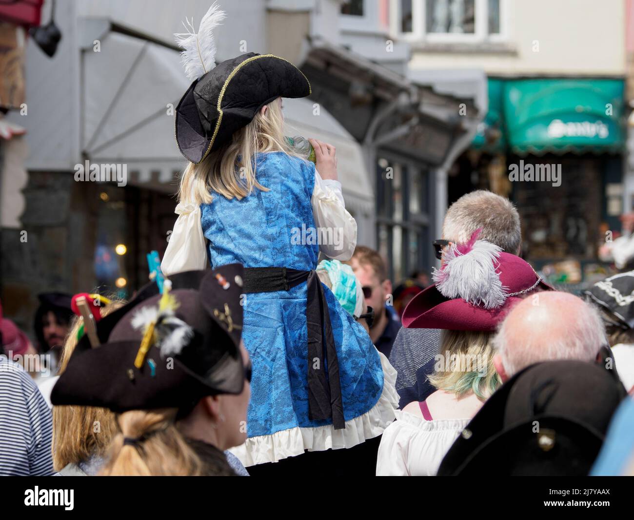 Il bambino viene trasportato sulle spalle del papà attraverso la folla al Brixham Pirate Festival 2022, Devon, Regno Unito Foto Stock