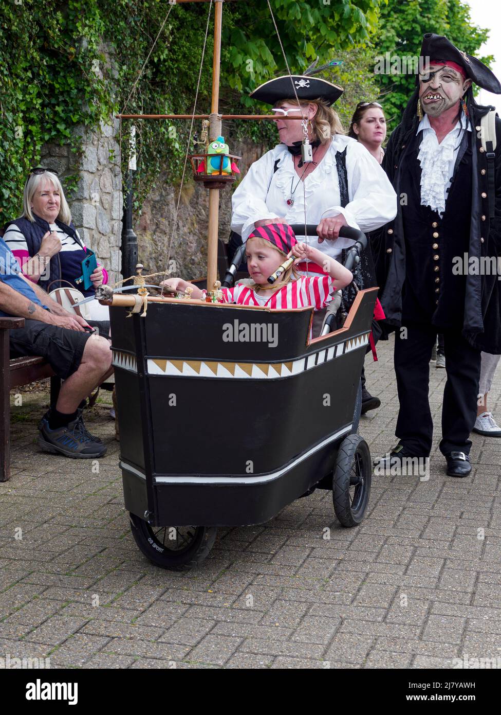 Famiglia con passeggino adattato per assomigliare ad una nave pirata a bordo del Brixham Pirate Festival 2022, Devon, Regno Unito Foto Stock