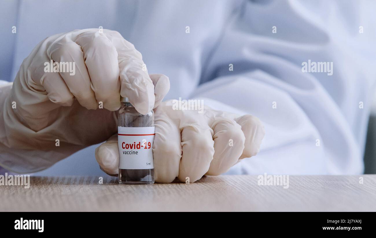 Primo piano le mani femminili di infermiere medico operatore medico che tiene una bottiglia di vaccino covid 19 vaso aperto di farmaco di coronavirus farmaco antibiotico liquido medicina Foto Stock