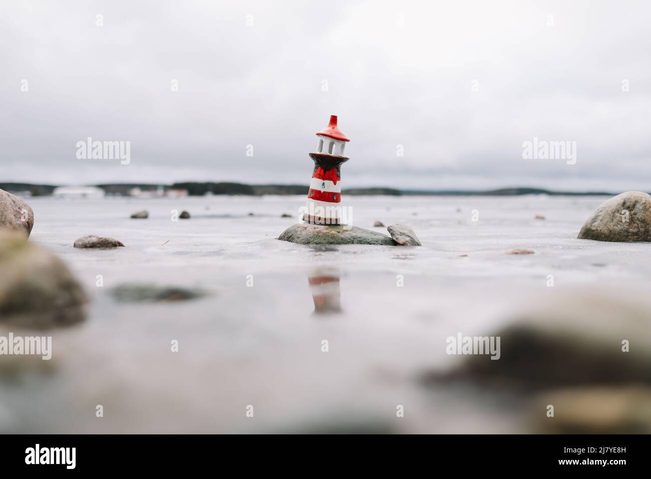 Mare d'inverno ghiacciato con faro decorativo. Stile di vita nautico. Inverno, Mare, Viaggi, avventura, vacanze e vacanza concetto. Foto Stock