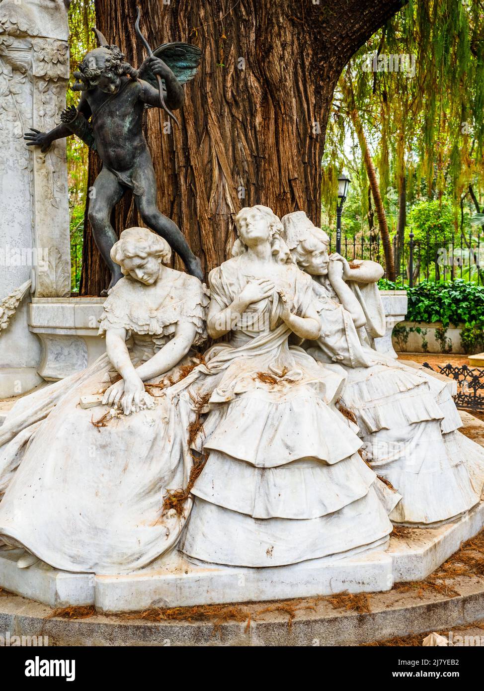 Gruppo scultoreo di Lorenzo Coullaut Valera nel giro di Gustavo Adolfo Bécquer. Tre figure femminili sedute su una panchina che simboleggia i tre stati d'amore: 'Amore eccitato', 'amore posseduto' e 'amore perso', e la statua di bronzo di Cupido che rappresenta 'l'amore che danneggia - Parco Maria Luisa - Siviglia, Spagna Foto Stock
