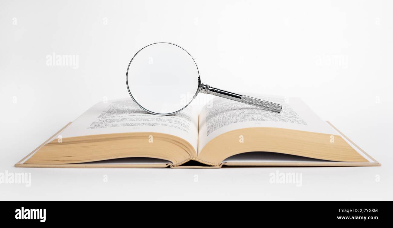 Apri libro con lente d'ingrandimento. Ricerca dei dati, concetto di conduzione della ricerca. Foto di alta qualità Foto Stock