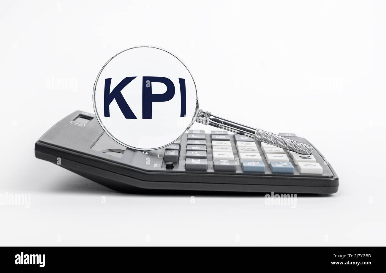 Indicatori chiave delle prestazioni. Lente di ingrandimento con lettere KPI alla calcolatrice. Calcolo e analisi delle metriche per monitorare i progressi nel raggiungimento degli obiettivi aziendali. Pianificazione strategica. Foto di alta qualità Foto Stock