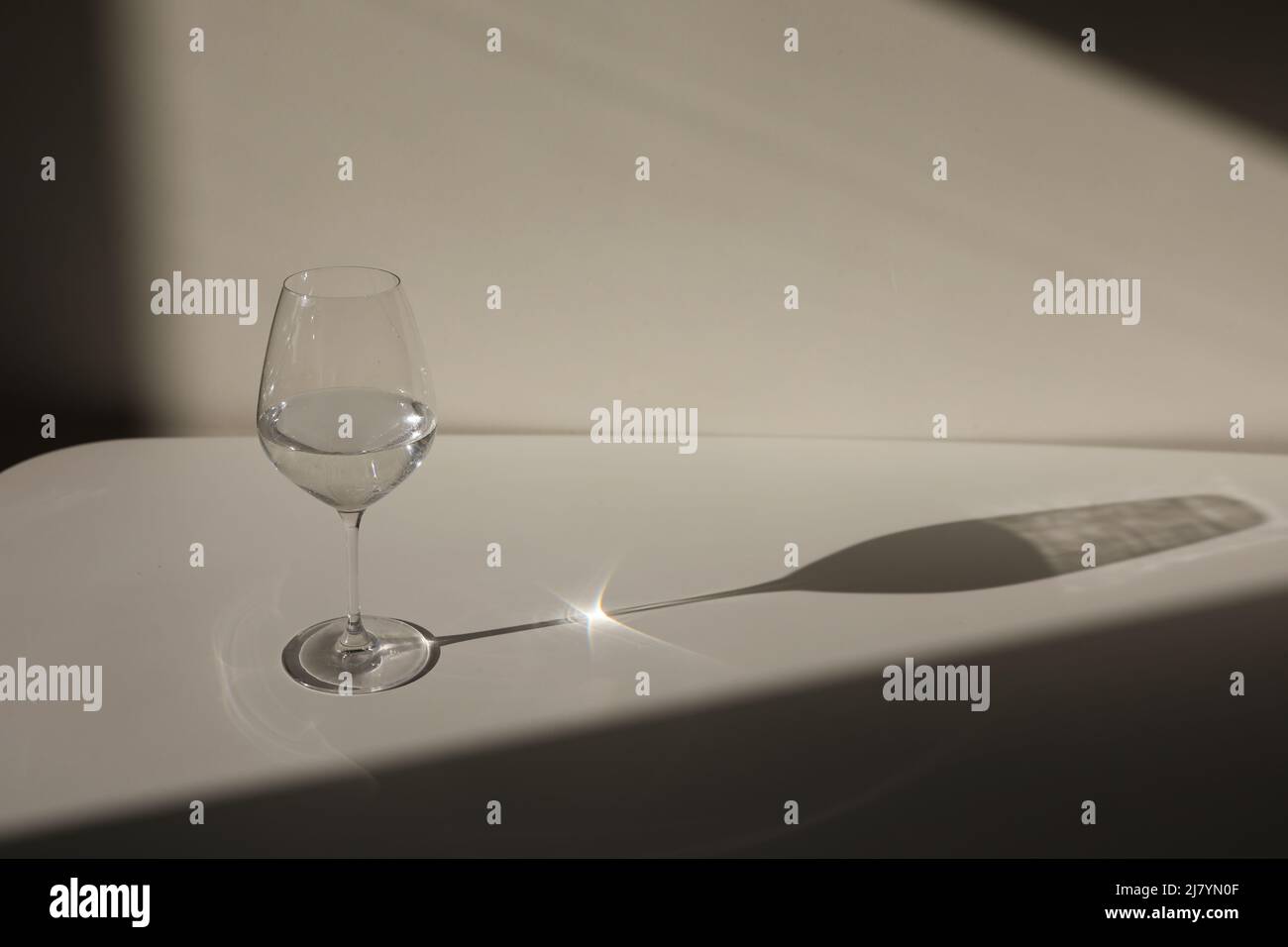 Un bicchiere d'acqua su sfondo bianco con un'ombra. Chiaroscuro dalla  finestra. Primo piano, spazio di copia Foto stock - Alamy