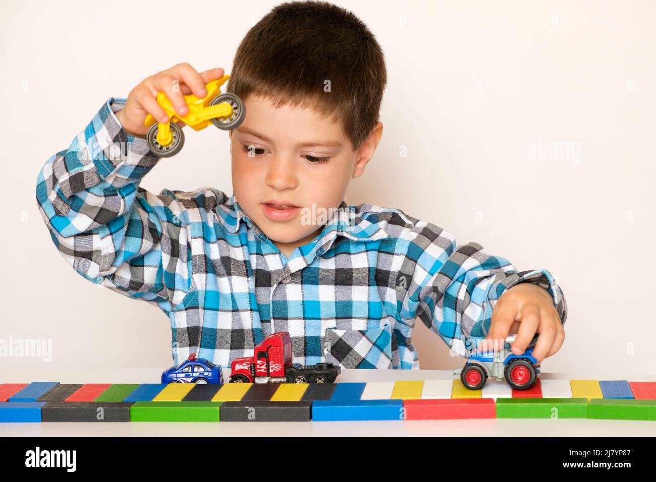 Bambino prescolare 4 anni gioca con auto e giocattoli, giochi per bambini,  negozio di giocattoli su sfondo bianco Foto stock - Alamy