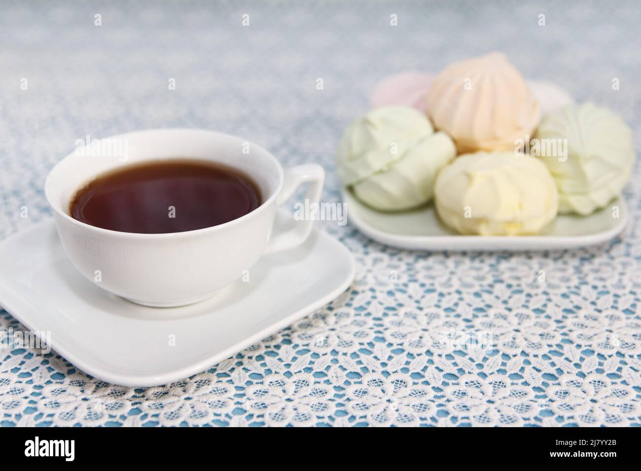 Tradizionale e delizioso tè preparato in una tazza e marshmallows d'aria si trovano sul tavolo, un dolce dessert Foto Stock