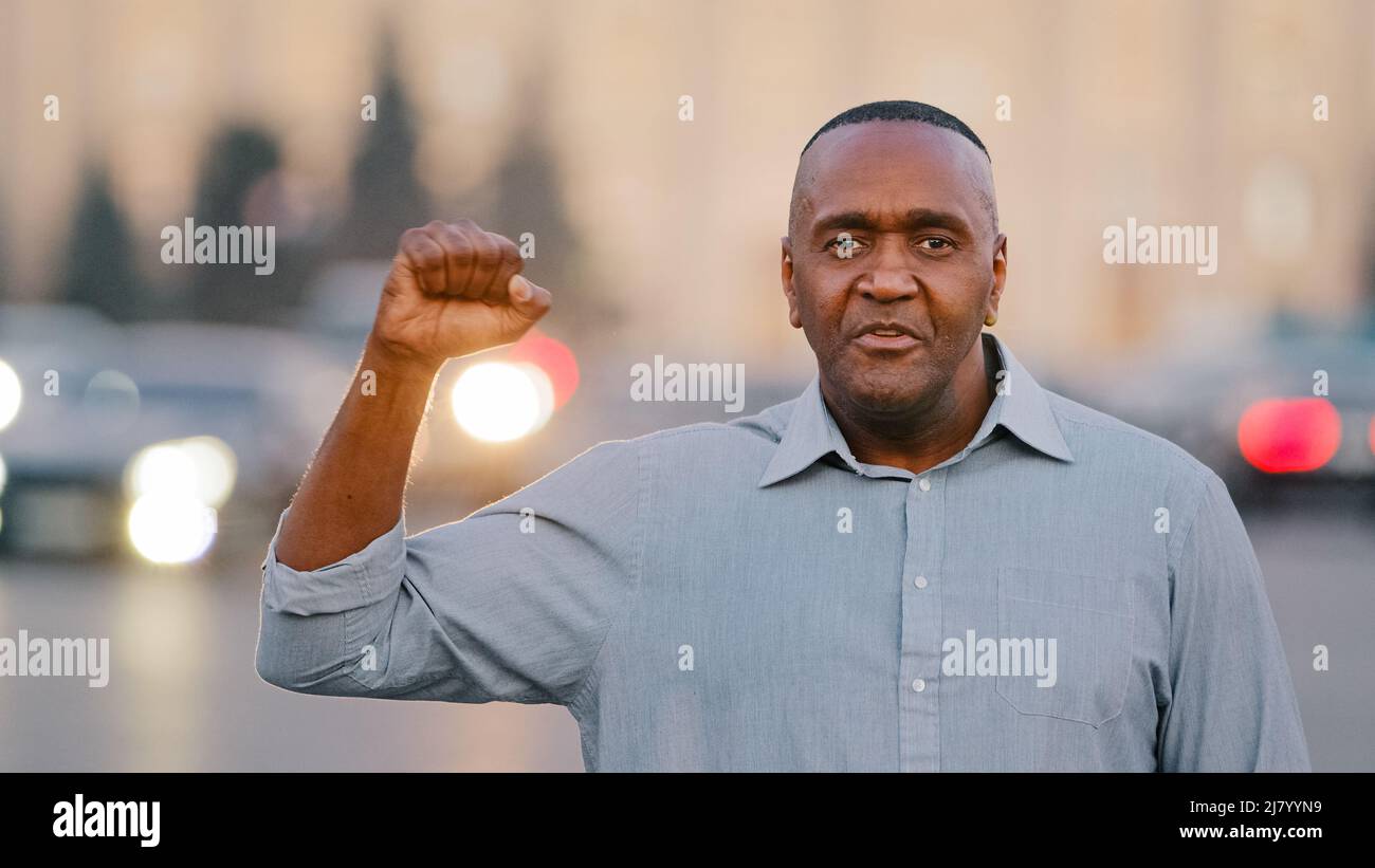Fiducioso Black African American età pensionabile uomo protesta contro la discriminazione in piedi guardando la macchina fotografica parlare con mano gesti pugno Foto Stock