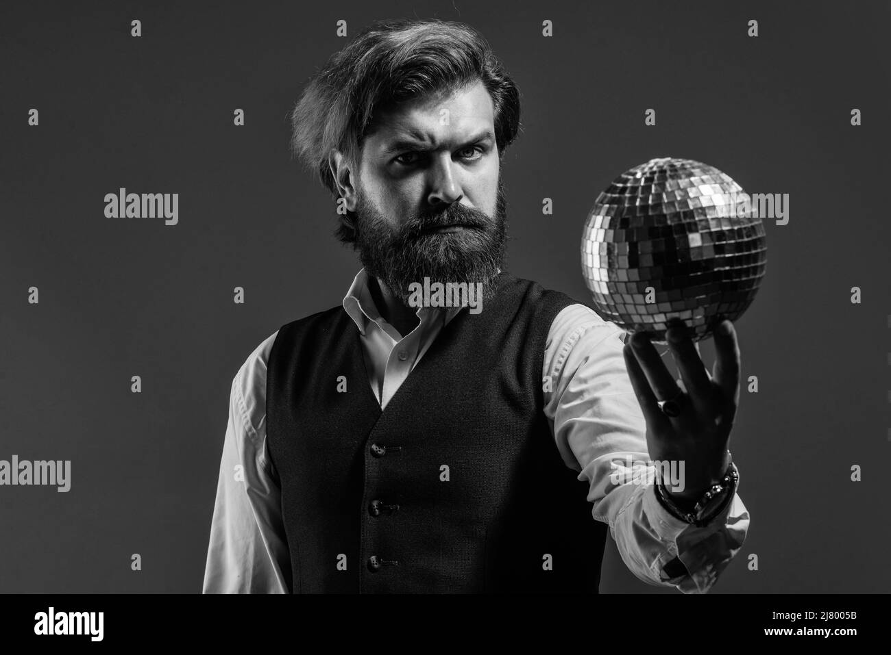 L'uomo maturo bearded tiene la sfera dorata della discoteca, concetto di vita notturna Foto Stock