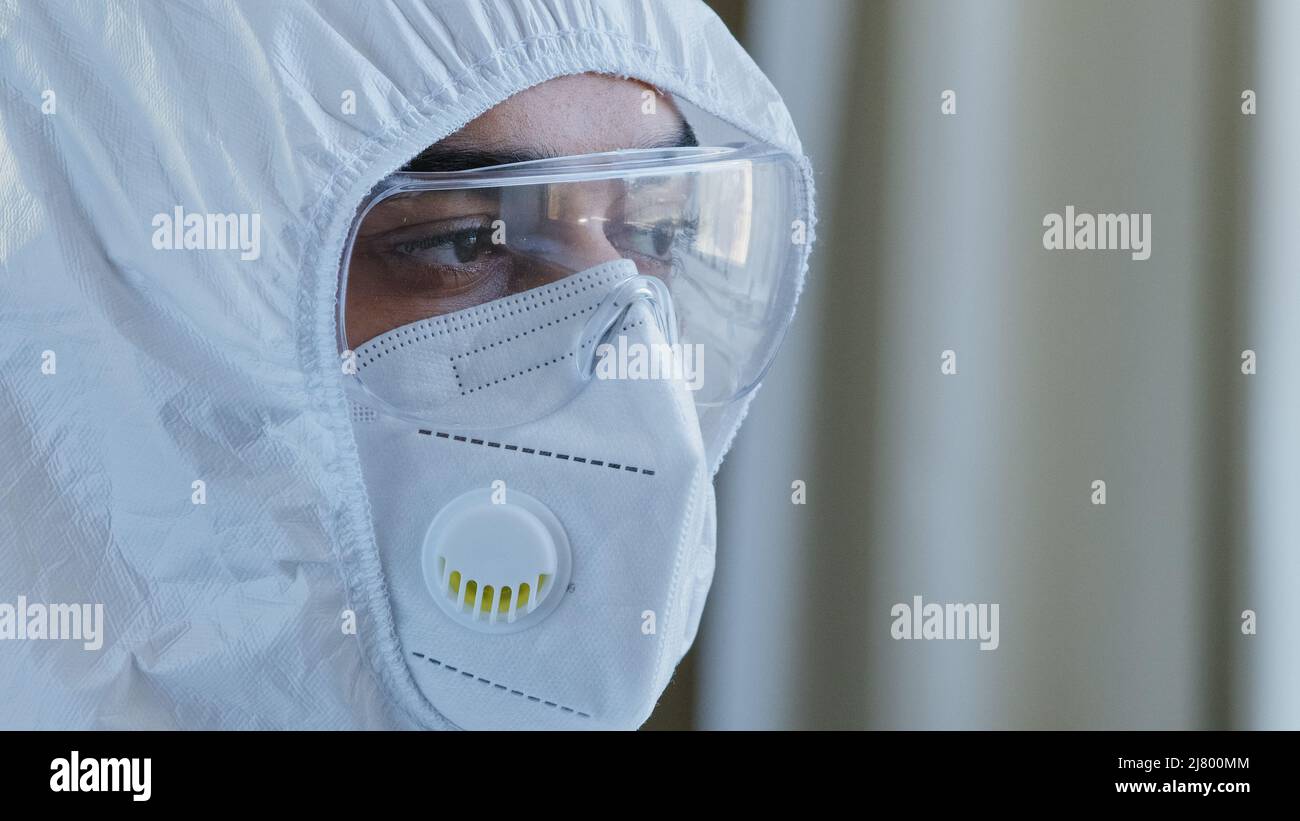 Ritratto di stanco sottolineato arabo spagnolo medico uomo maschio viso e occhi in occhiali di sicurezza e maschera di protezione speciale uniforme medica guardare Foto Stock