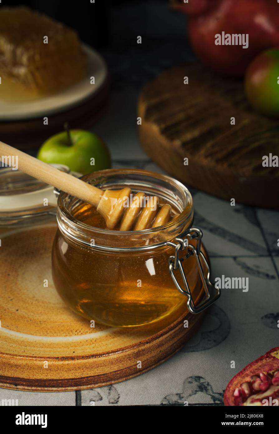 Vaso di vetro con miele fresco, cucchiaio di miele, mela e melograno. Concetto Ebraico Capodanno Happy Holiday Rosh Hashanah. Layout di simboli tradizionali. Foto Stock