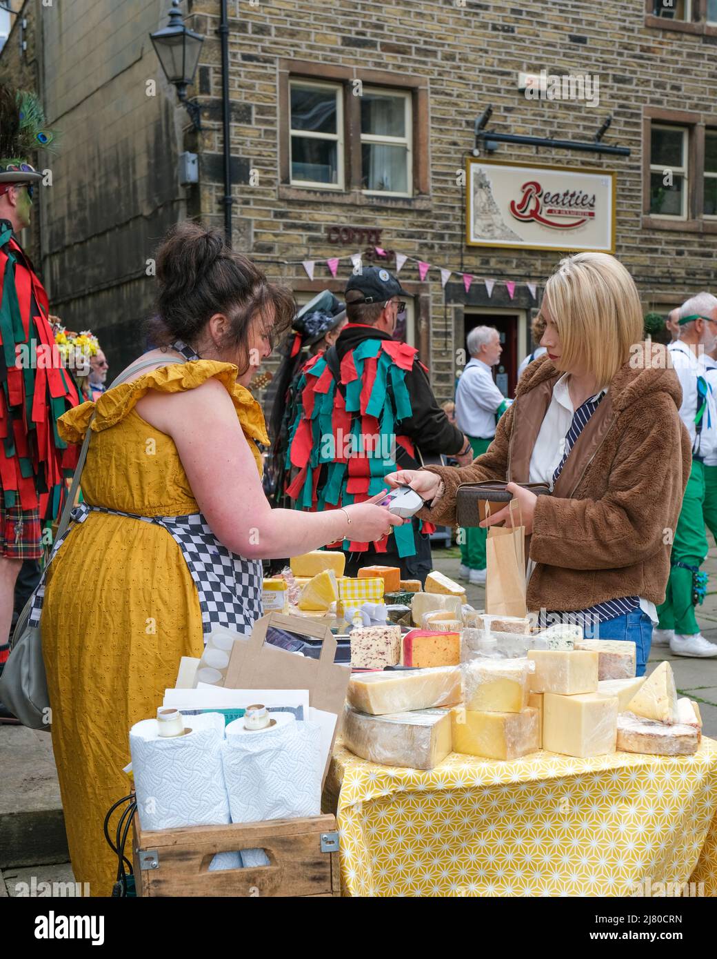 Una bancarella di formaggi nella città di Holmfirth nello Yorkshire occidentale durante il festival folk annuale. Due donne stanno completando una transazione. Foto Stock