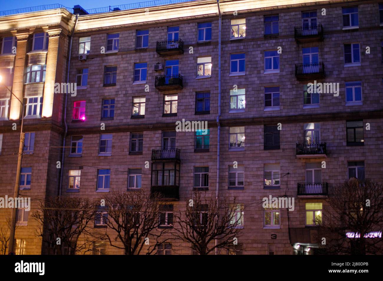 finestre notturne illuminate di case in città Foto Stock