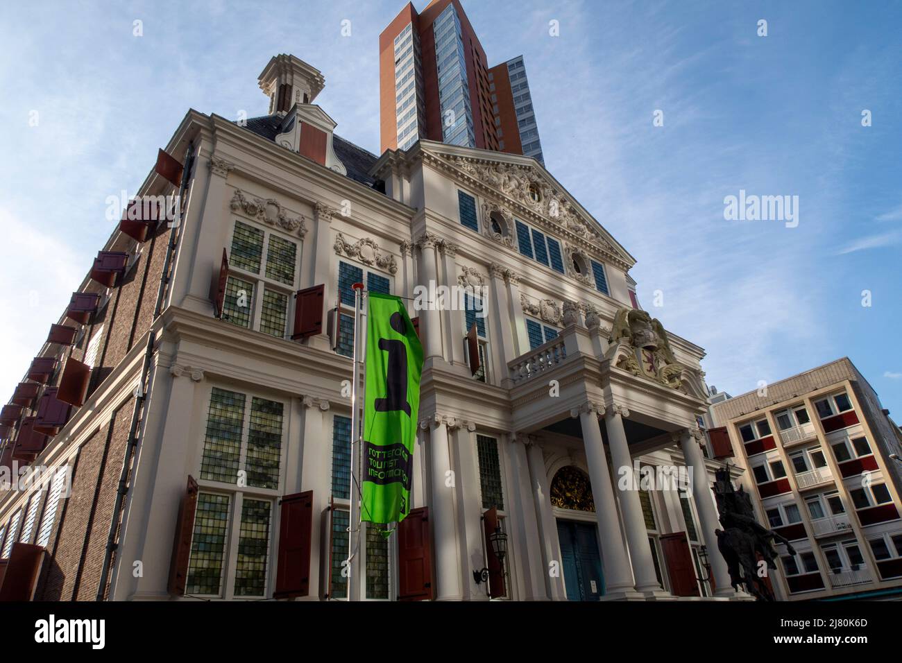 Storico edificio bianco con persiane rosse e architettura classica in un ambiente urbano sotto un cielo blu Foto Stock