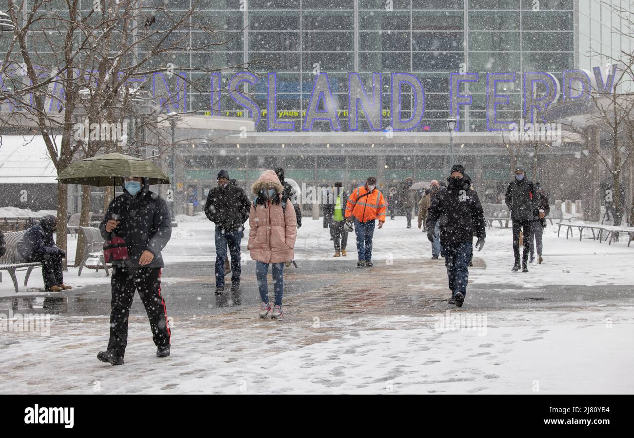 NEW YORK, N.Y. – 18 febbraio 2021: Le persone sono viste vicino al terminal dei traghetti di Staten Island a Lower Manhattan durante una tempesta invernale. Foto Stock