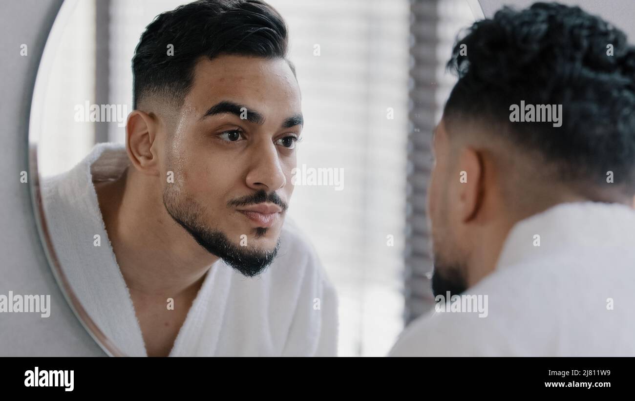 Specchio riflessione ritratto arabo arabo indiano bearded uomo lavaggio viso maschio bagnato con acqua calda fredda ragazzo mattina doccia routine di cura della pelle Foto Stock