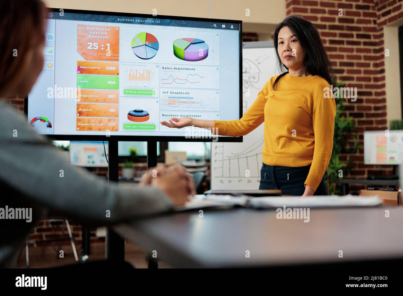 Donne d'affari che lavorano alle idee di vendita che analizzano le statistiche durante la riunione di affari nell'ufficio di startup. Il team di gestione discute della strategia aziendale che pianifica il progetto di partnership. Ambiente di lavoro moderno Foto Stock