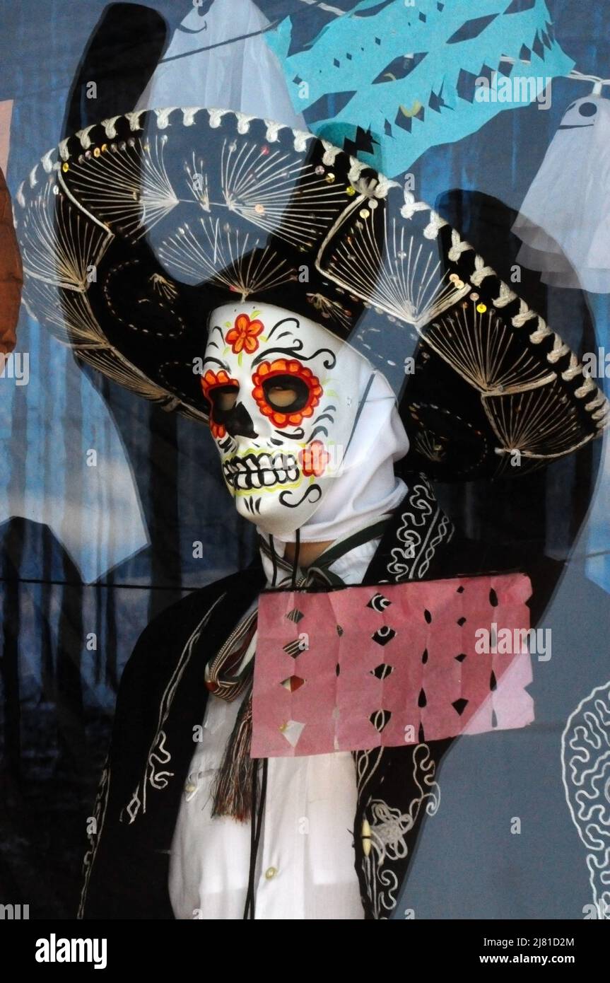 Giorno del costume morto con maschera dipinta e cappello di sombrero dietro la finestra Foto Stock