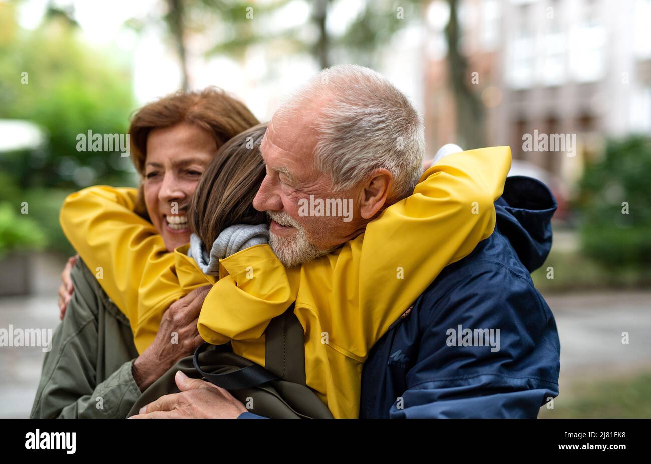 Nonni felici con nonna di preteen hugging insieme i portelli d'ora in via della città Foto Stock