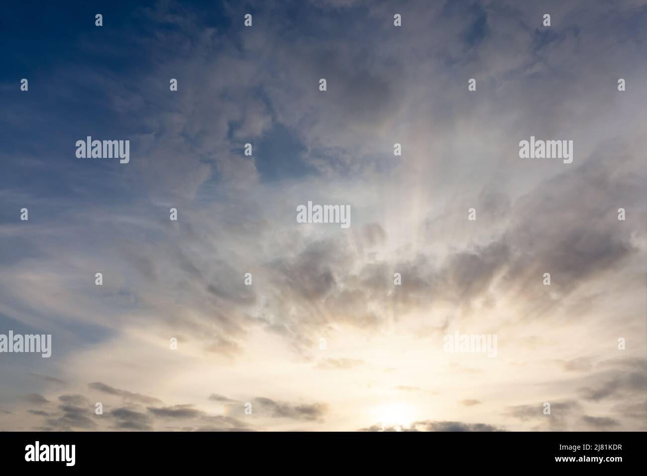 Incredibile cielo al tramonto con raggi solari e nuvole. Sole all'orizzonte con paesaggio nuvoloso Foto Stock