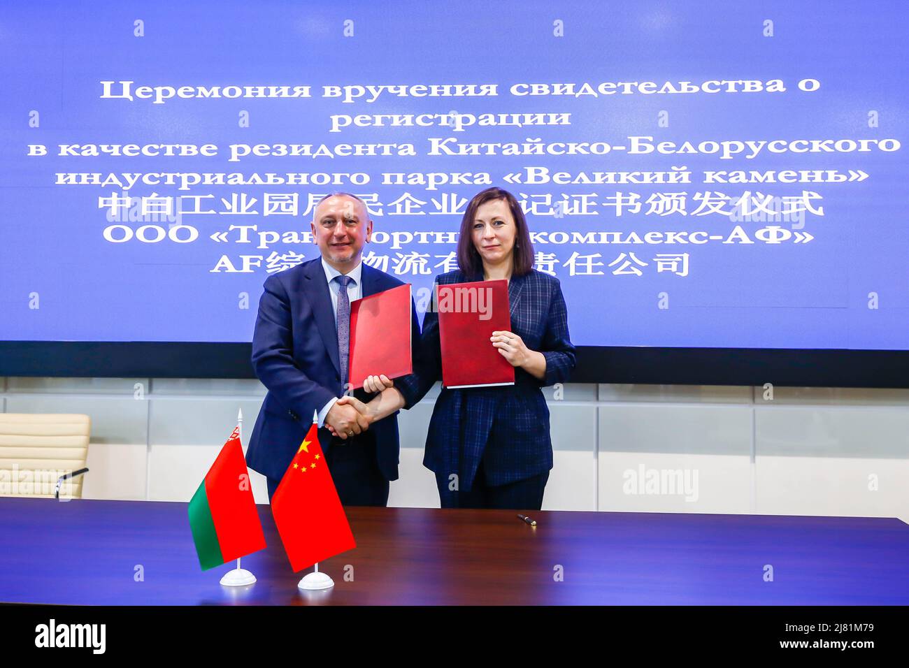 (220512) -- MINSK, 12 maggio 2022 (Xinhua) -- il 11 maggio 2022, il capo dell'amministrazione del parco industriale di Great Stone China-Belarus Alexander Yaroshenko (L) rilascia un certificato di ammissione ad un rappresentante dell'impresa cinese Transport Complex AF LLC a Minsk, Bielorussia. Il parco industriale di Great Stone Cina-Bielorussia, un progetto di cooperazione di riferimento nel quadro di Belt and Road, ha tenuto mercoledì una cerimonia di benvenuto per una nuova società residente. L'impresa cinese Transport Complex AF LLC, la società residente nel 90th del parco industriale situato nella periferia orientale di Minsk, prevede di fare il suo ingresso Foto Stock