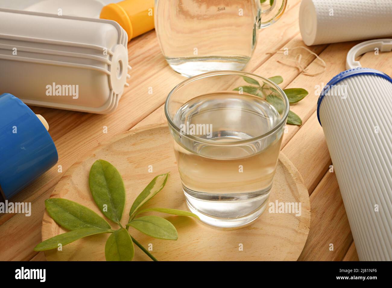 Vetro di acqua filtrata con sistema ad osmosi inversa con filtri su tavola di legno. Vista rialzata. Composizione orizzontale. Foto Stock