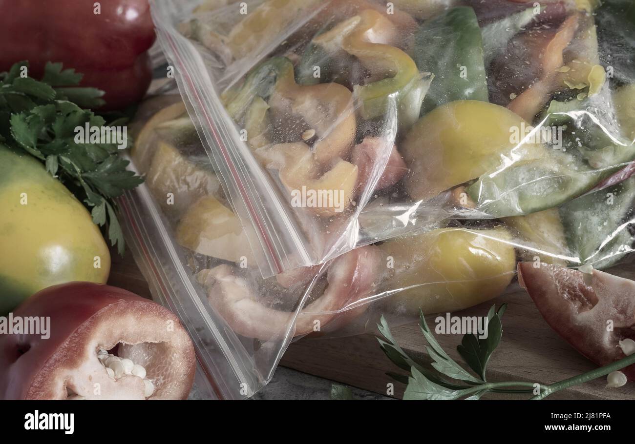 Affettato frutti maturi di peperone in sacchetti di cellophane, preparati per il congelamento e la conservazione a lungo termine nel comparto freezer del frigorifero. V. Anteriore Foto Stock