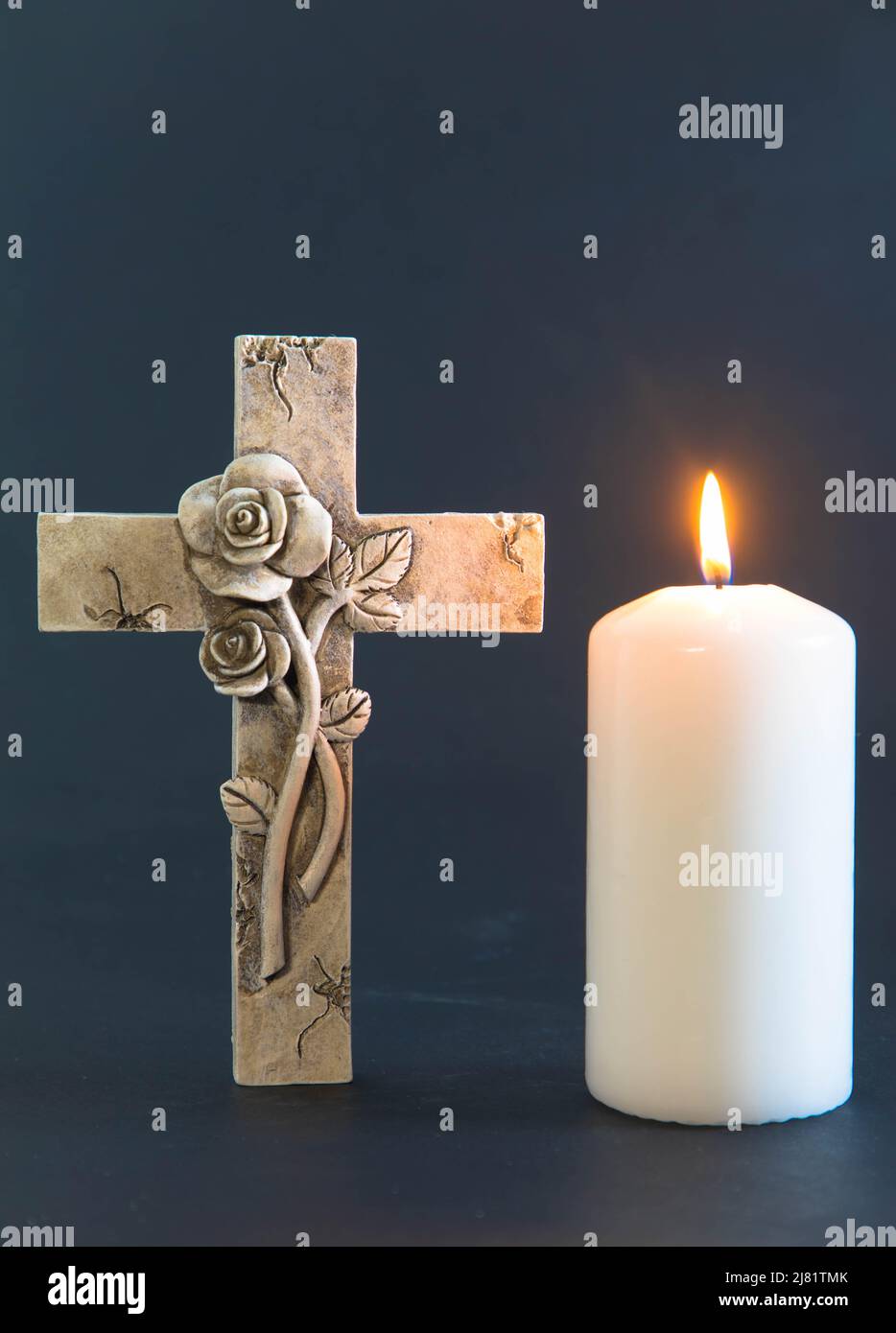 Croce religiosa e candela bruciante con sfondo nero. Condolence e concetto di simpatia. Foto Stock