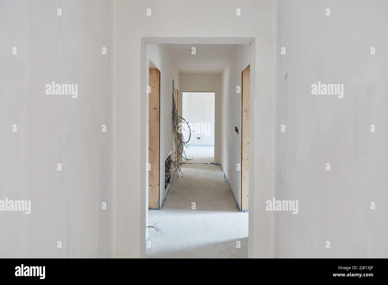 Riempimento e intonacatura delle pareti nel corridoio di un nuovo edificio durante il design degli interni Foto Stock