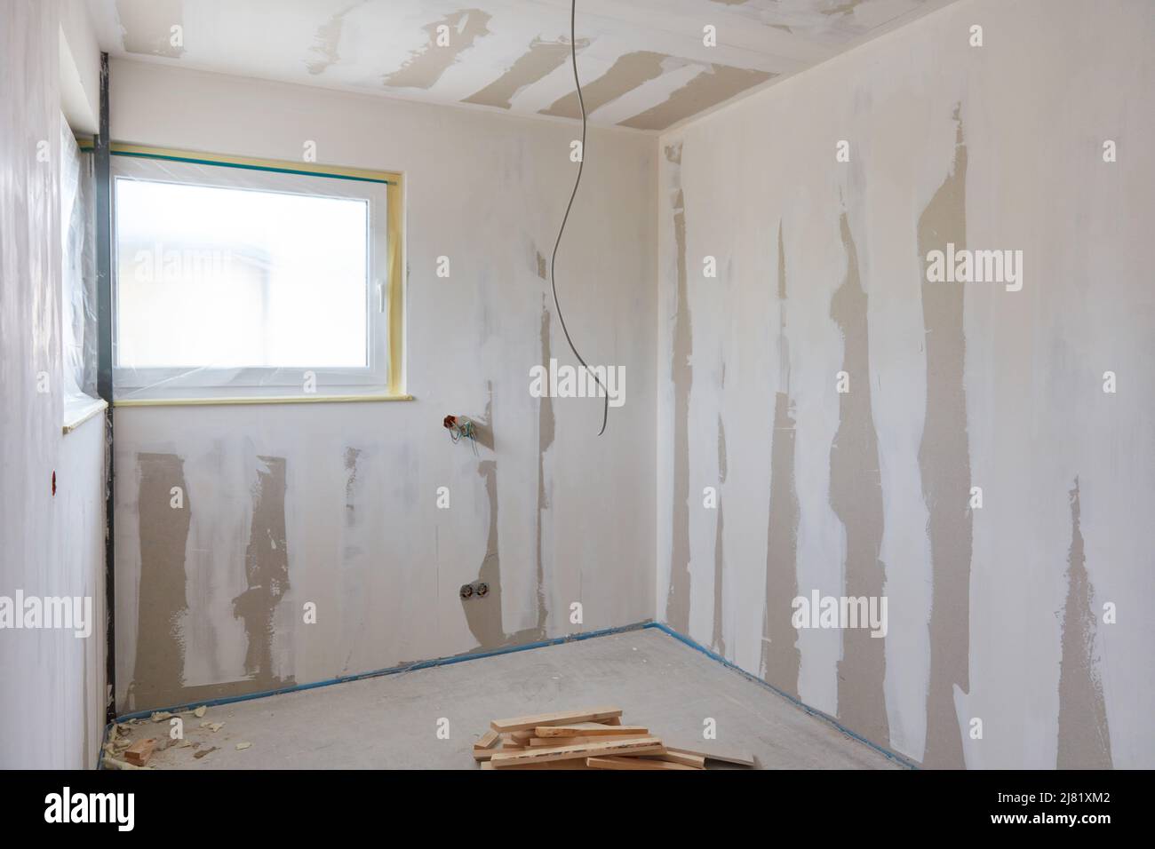 Stanza vuota dopo lavori di stucco su parete e soffitto durante la costruzione della casa Foto Stock