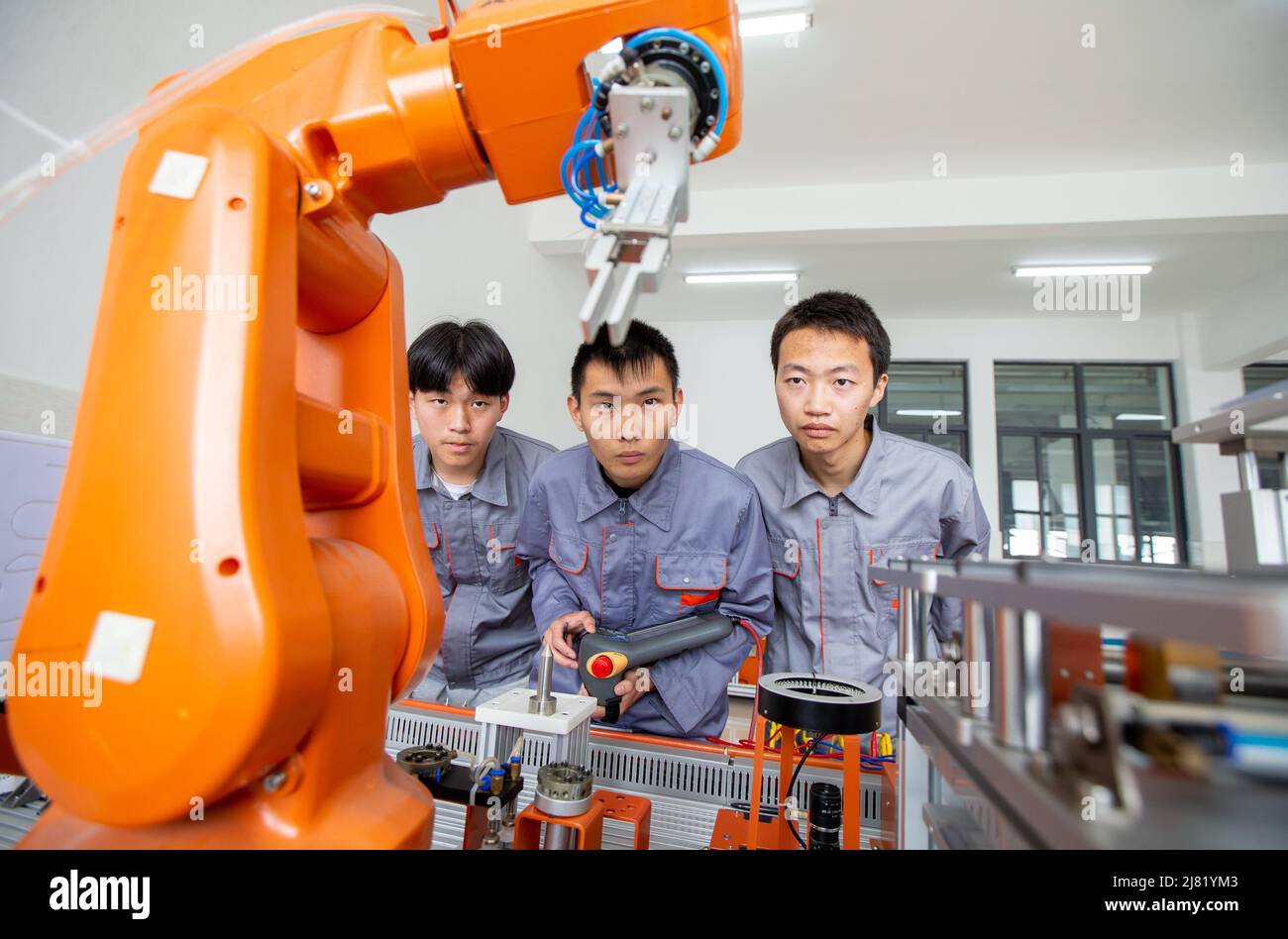 NANTONG, CINA - 12 MAGGIO 2022 - gli studenti gestiscono un robot industriale in una scuola professionale a Nantong, nella provincia di Jiangsu della Cina orientale, il 12 maggio 2022. Foto Stock