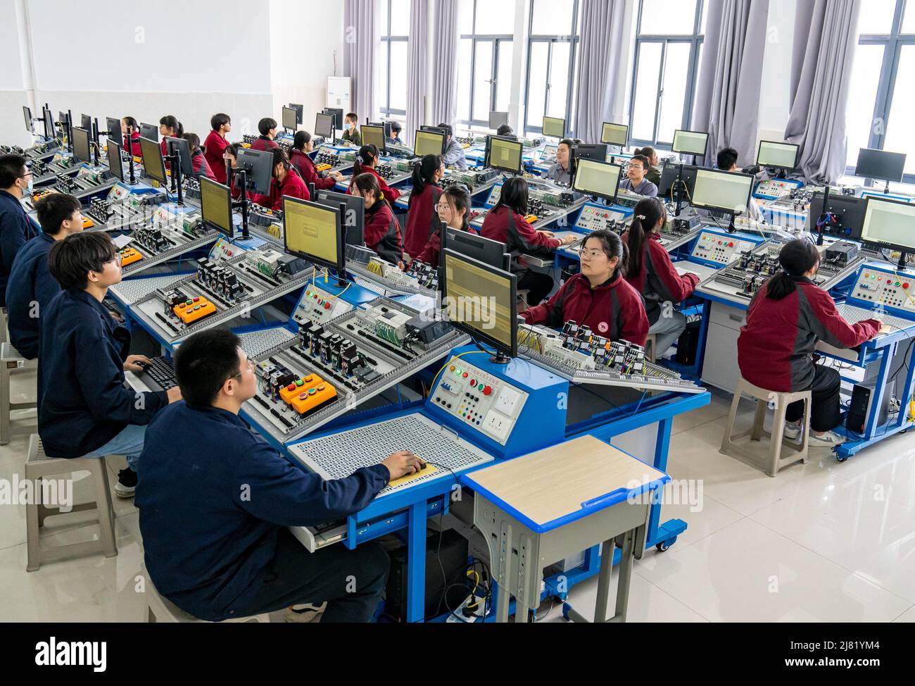 NANTONG, CINA - 12 MAGGIO 2022 - studenti di scuola professionale in sala di formazione elettrica PLC a Nantong City, Jiangsu Province, Cina, maggio 12 Foto Stock
