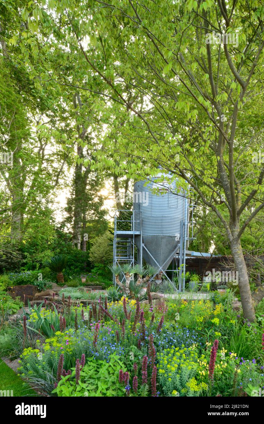 Un ridefiniti silo di grano circondato da piantagione naturalistica della resilienza giardino disegnato da Sarah Eberle al RHS Chelsea Flower Show 2019. Foto Stock