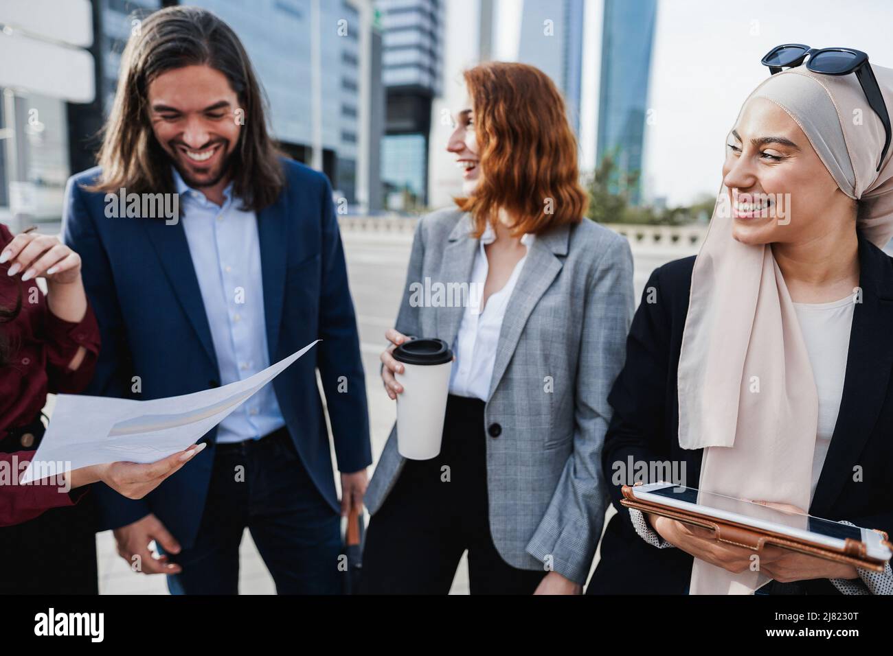 Uomini d'affari multietnici che lavorano all'aperto dall'edificio di uffici - Focus principale sugli occhiali da sole musulmani Foto Stock